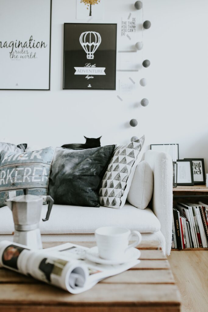 photo d'un salon, canapé blanc, cadres au mur et table basse palette - ambiance cosy